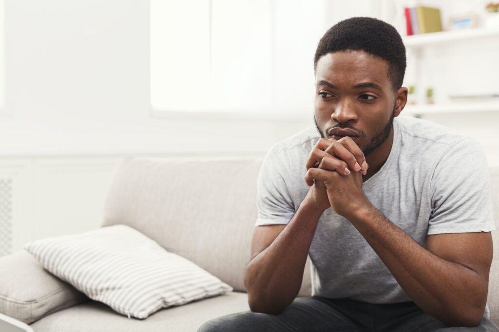 Disappointed young african-american man at home