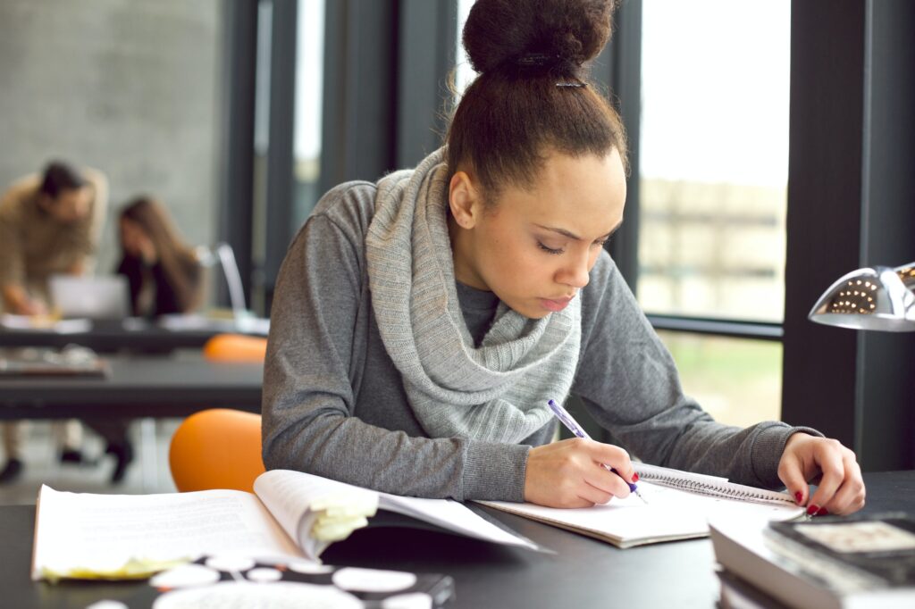 Young african american woman taking notes for her study